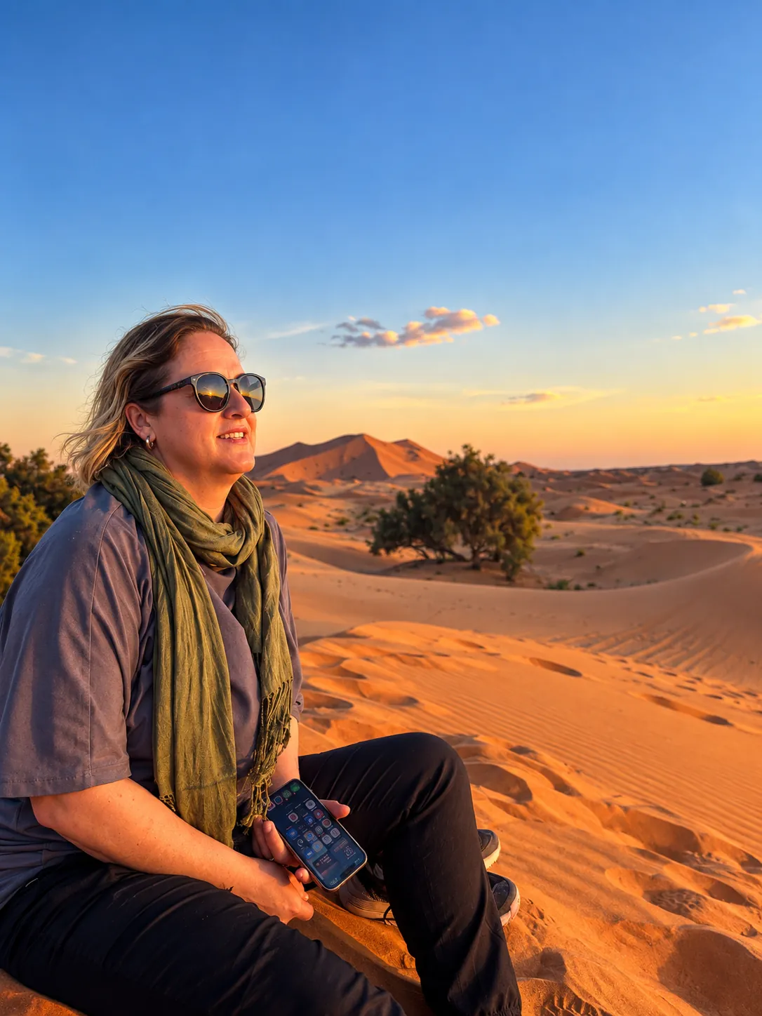 Elsa sentada en lo alto de una duna, mirando el atardecer sobre el Sahara
