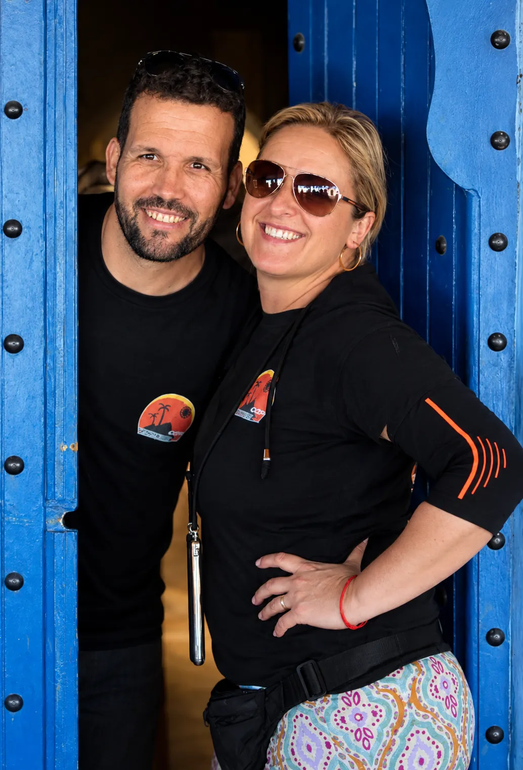 Elsa y Moha abrazados en el umbral de una puerta azul tradicional marroquí